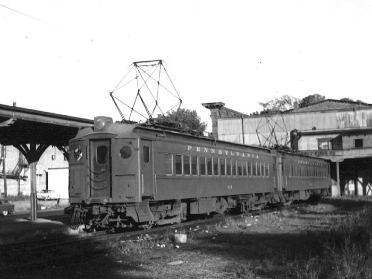 Vintage electric train at a station with 'Pennsylvania' on the side.